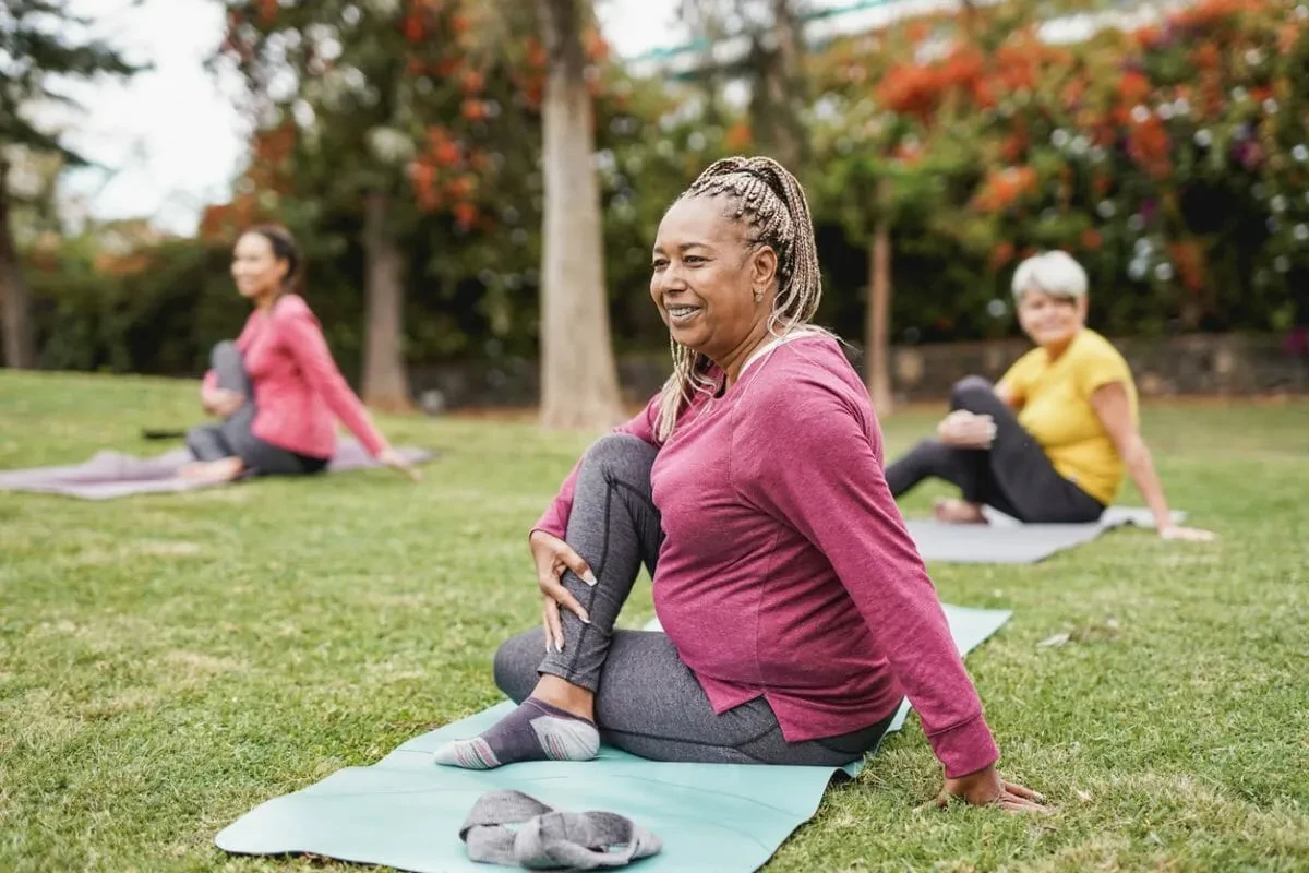 Women doing outdoor yoga together in a park — wellness and community at Porchaven™